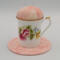 This is the frontal view of the teacup pincushion with the trivet. the flowers are enhanced by the color of the fabric.